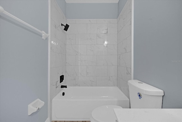 bathroom with toilet and tiled shower / bath