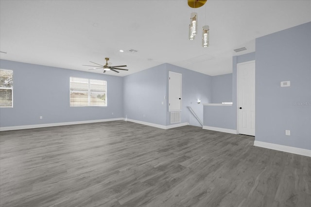 unfurnished living room featuring ceiling fan and dark hardwood / wood-style flooring