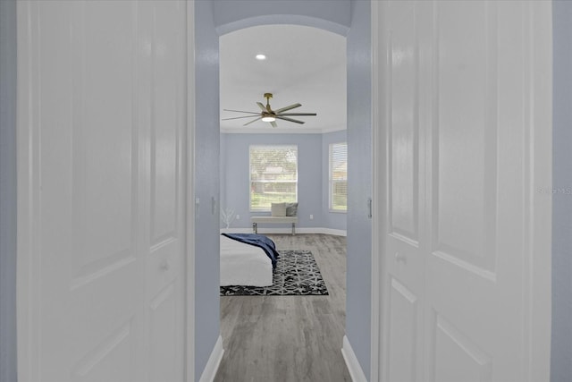 corridor with crown molding and light hardwood / wood-style floors