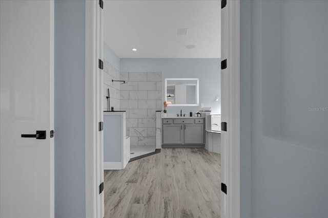 bathroom featuring a shower, vanity, and hardwood / wood-style flooring