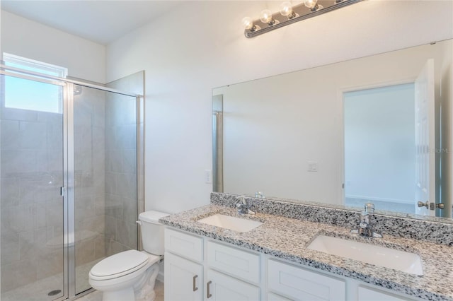 bathroom with a shower with door, vanity, and toilet