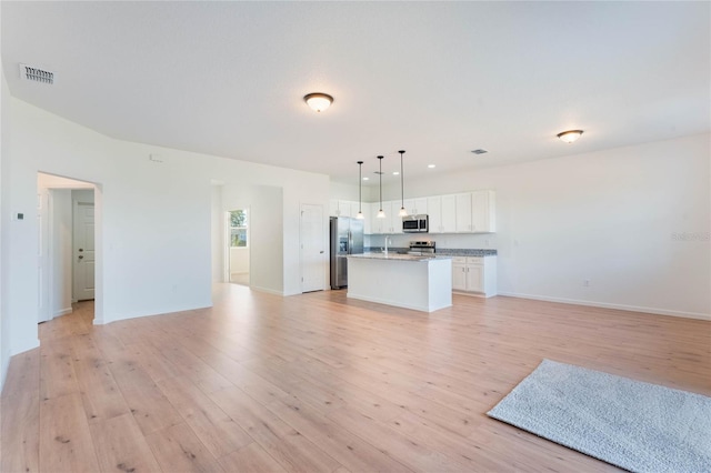 unfurnished living room with sink and light hardwood / wood-style flooring