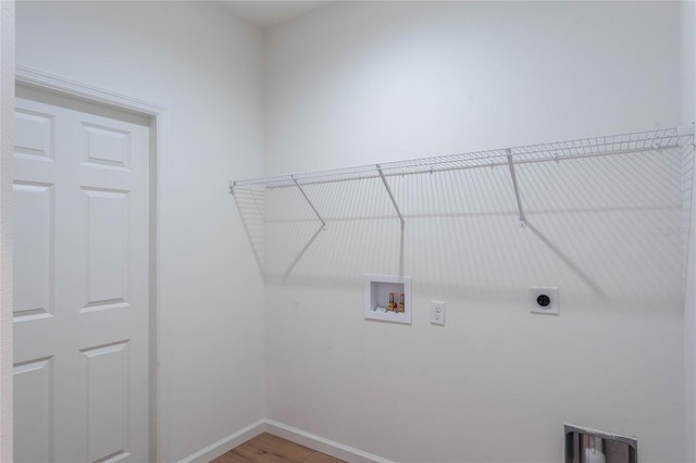 clothes washing area with electric dryer hookup, washer hookup, and hardwood / wood-style flooring