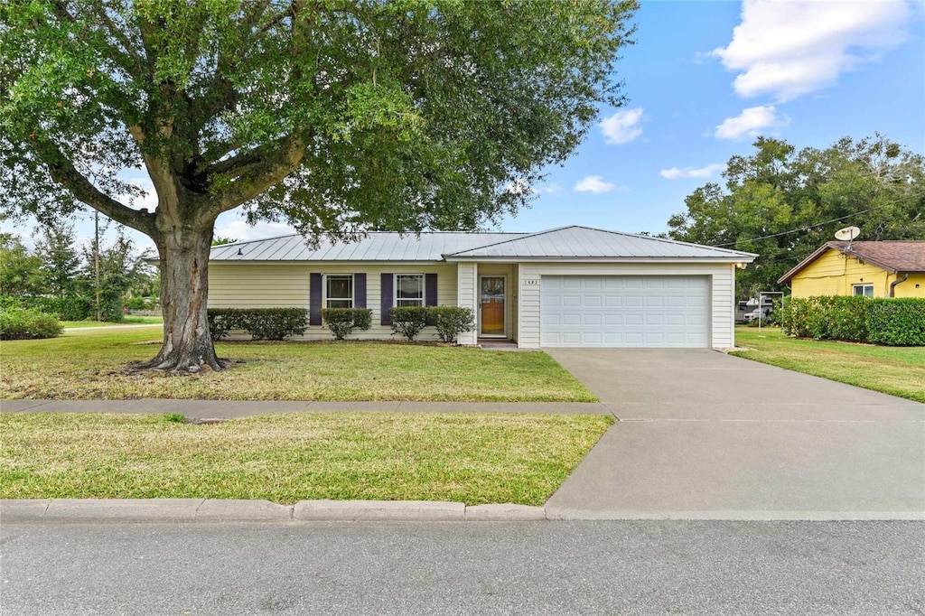 ranch-style home with a garage and a front yard