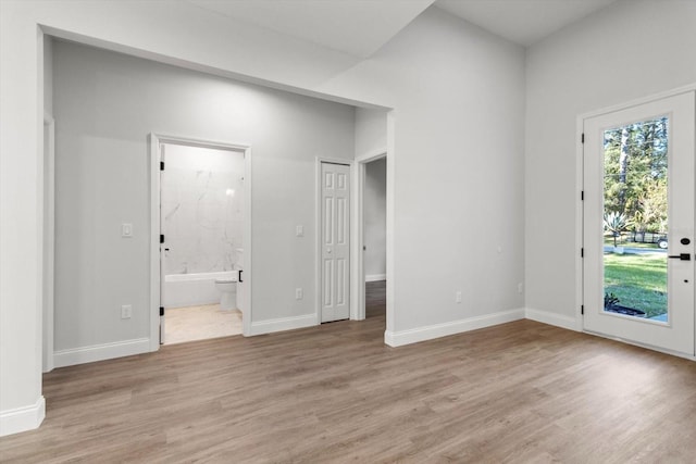 interior space featuring access to exterior, ensuite bathroom, and light hardwood / wood-style floors