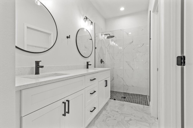 bathroom with a tile shower and vanity