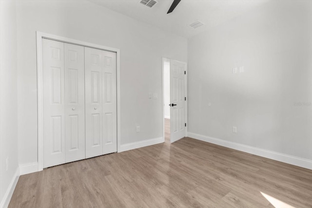 unfurnished bedroom featuring ceiling fan, a closet, and light hardwood / wood-style flooring