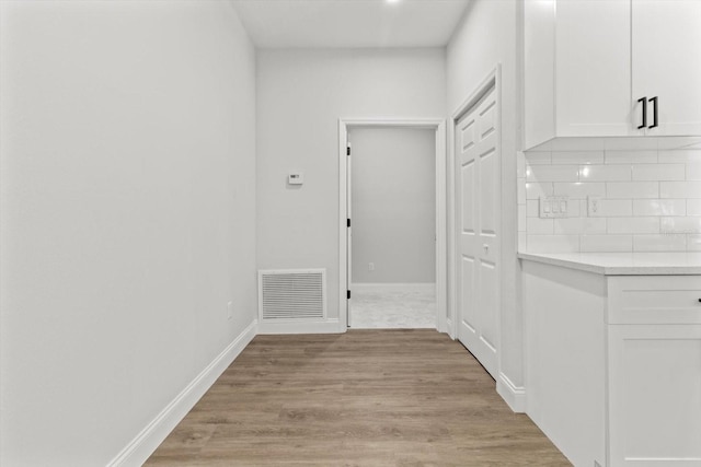 corridor with light hardwood / wood-style flooring