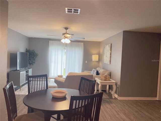 dining room featuring ceiling fan, a textured ceiling, and hardwood / wood-style flooring