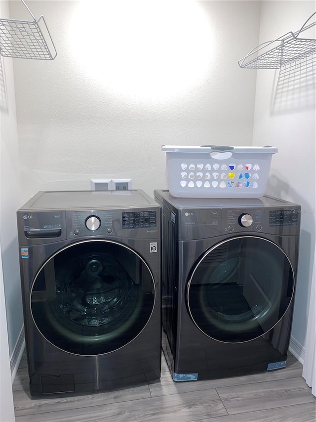 laundry area featuring hardwood / wood-style floors and washing machine and dryer