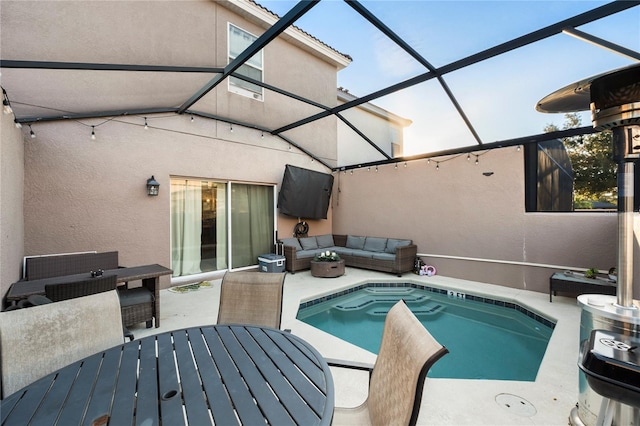 view of swimming pool with an outdoor living space, a patio, and glass enclosure