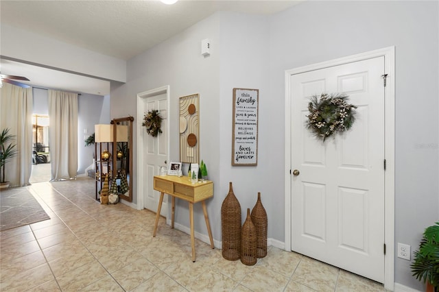 tiled entrance foyer featuring ceiling fan