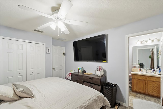 bedroom with light carpet, ensuite bathroom, a textured ceiling, ceiling fan, and sink