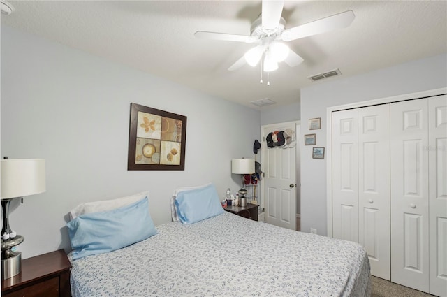 carpeted bedroom featuring ceiling fan, a textured ceiling, and a closet