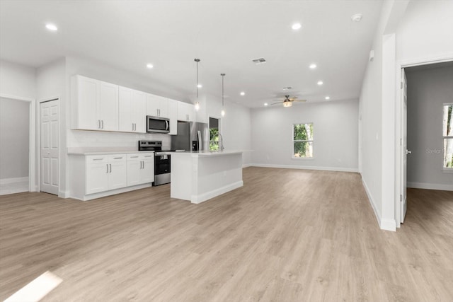 kitchen with stainless steel appliances, ceiling fan, decorative light fixtures, white cabinetry, and a kitchen island