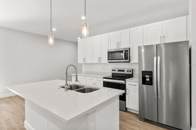 kitchen with sink, stainless steel appliances, pendant lighting, a center island with sink, and light wood-type flooring