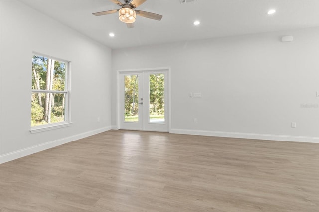 unfurnished room with french doors, light hardwood / wood-style floors, ceiling fan, and a healthy amount of sunlight