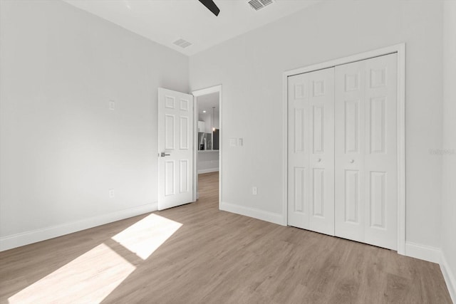 unfurnished bedroom with a closet, light hardwood / wood-style flooring, and ceiling fan