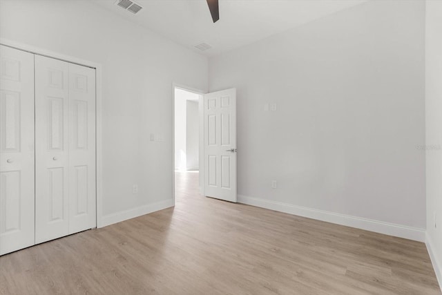 unfurnished bedroom with a closet, light hardwood / wood-style floors, and ceiling fan