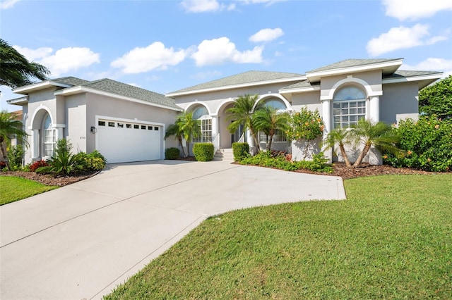 mediterranean / spanish home featuring a garage and a front lawn