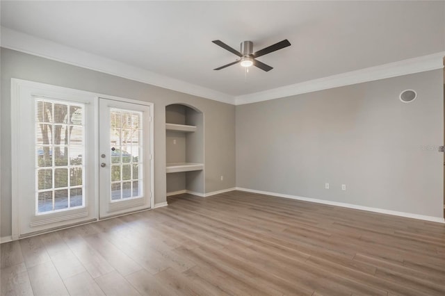 interior space featuring built in shelves, crown molding, and wood-type flooring