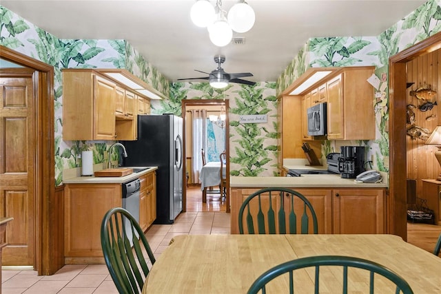 kitchen featuring light tile patterned floors, ceiling fan with notable chandelier, stainless steel appliances, and sink