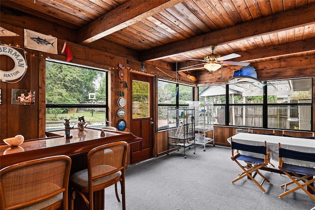 sunroom with beamed ceiling, ceiling fan, and wooden ceiling