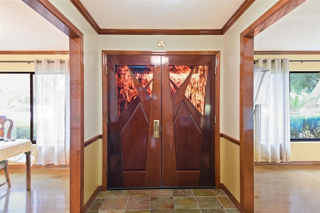 entryway featuring a textured ceiling and ornamental molding