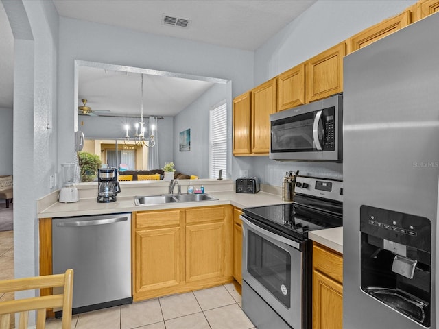 kitchen featuring appliances with stainless steel finishes, sink, light tile patterned floors, a notable chandelier, and hanging light fixtures