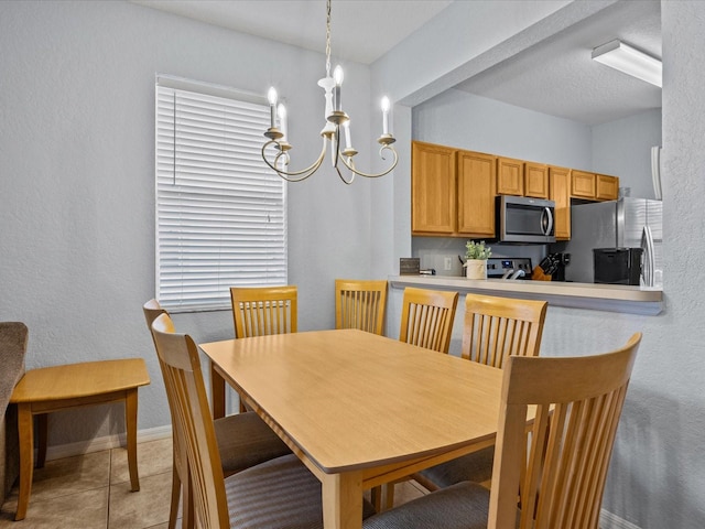 tiled dining space with a chandelier