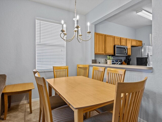 408 Miramar Ave, Davenport, FL 33897 - dining room featuring a chandelier, light tile patterned floors, baseboards, and a textured wall