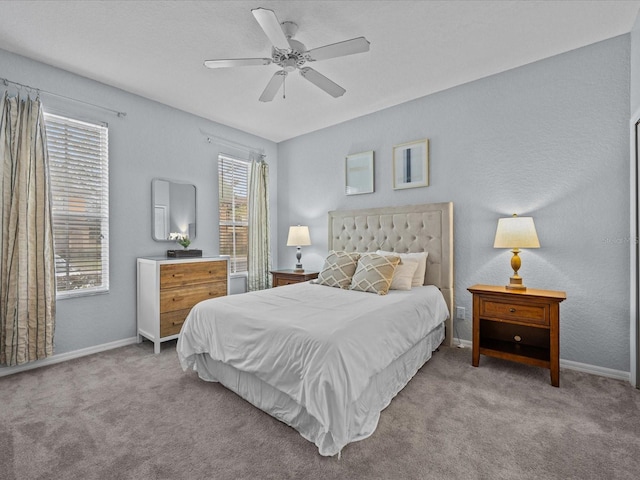 carpeted bedroom featuring ceiling fan and multiple windows