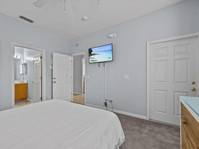 408 Miramar Ave, Davenport, FL 33897 - carpeted bedroom with baseboards, connected bathroom, and a ceiling fan