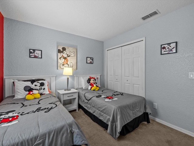 bedroom featuring carpet floors, a textured ceiling, and a closet