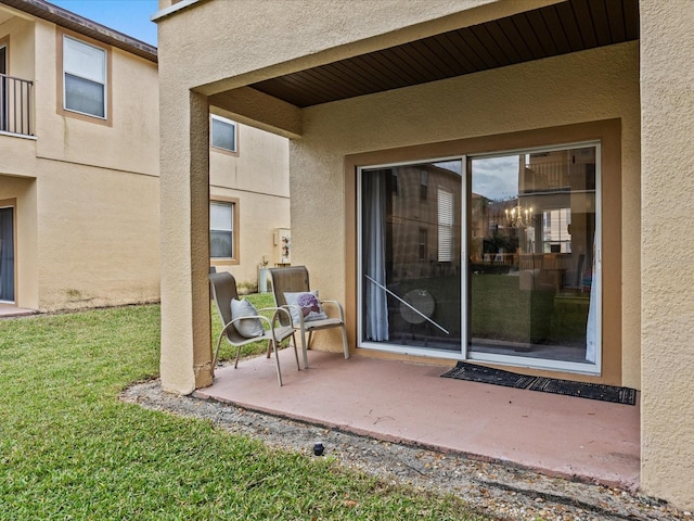 property entrance with a patio area and a yard