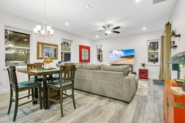 interior space with ceiling fan with notable chandelier and light hardwood / wood-style floors