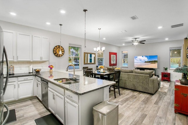 kitchen featuring pendant lighting, white cabinets, kitchen peninsula, and sink