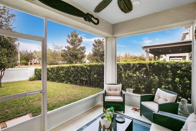 sunroom featuring ceiling fan and a healthy amount of sunlight