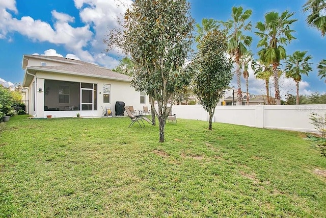 back of house featuring a sunroom and a lawn