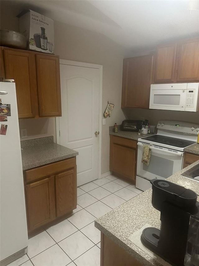 kitchen with light tile patterned floors and white appliances