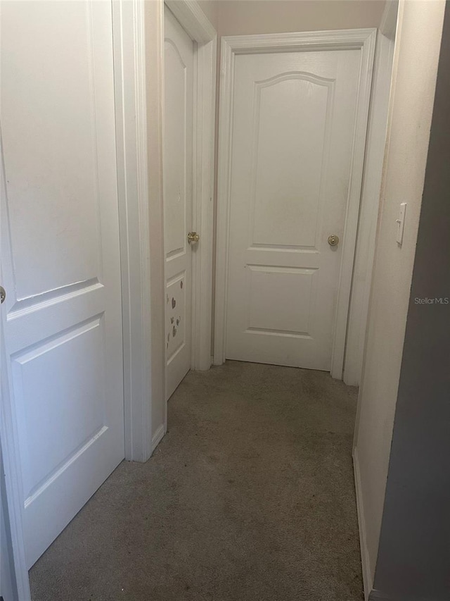 hallway featuring light colored carpet