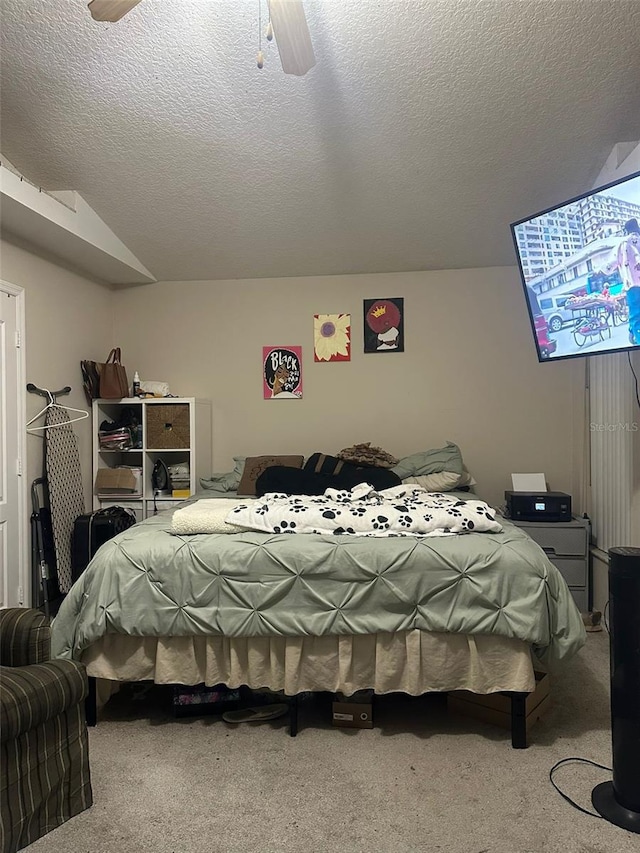 bedroom featuring carpet flooring, a textured ceiling, and ceiling fan