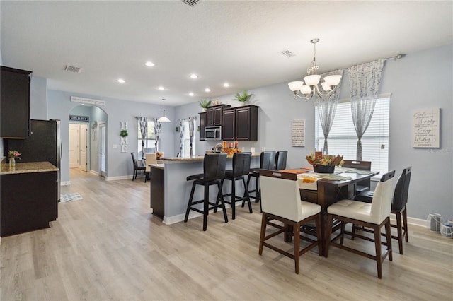 dining room featuring a notable chandelier and light wood-type flooring