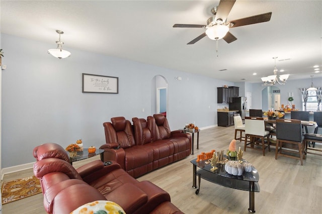 living room featuring light hardwood / wood-style floors and ceiling fan with notable chandelier