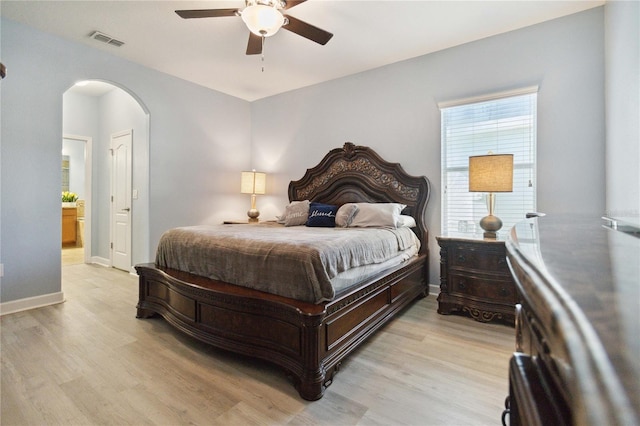 bedroom featuring light wood-type flooring, ensuite bath, and ceiling fan