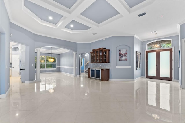 unfurnished living room with decorative columns, french doors, a healthy amount of sunlight, and ornamental molding