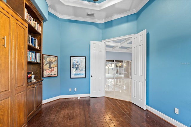 spare room with dark wood-type flooring, ornamental molding, and coffered ceiling