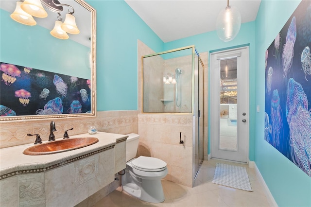 bathroom with a shower with door, sink, tile patterned flooring, toilet, and tile walls