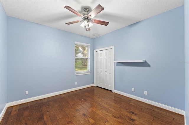 empty room featuring a textured ceiling, ceiling fan, and dark hardwood / wood-style floors