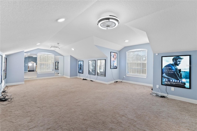 interior space with a textured ceiling and vaulted ceiling